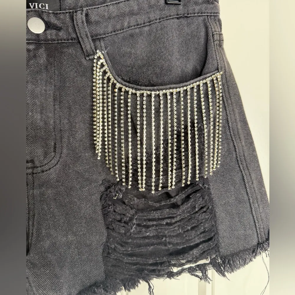 Black distressed denim shorts with rhinestone fringe pockets. Brand: Vici Size L - Image 3