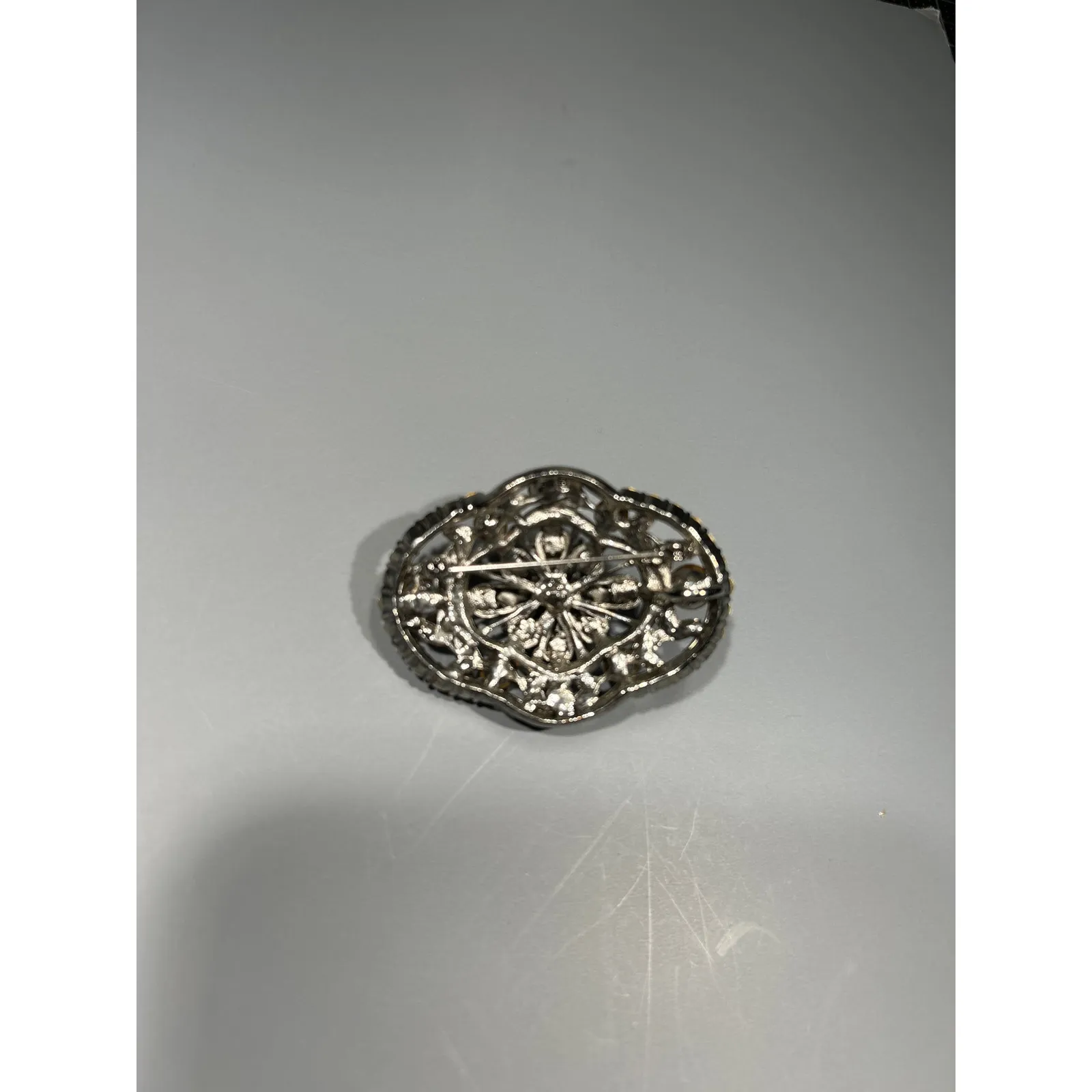 Oval brooch with aurora borealis and clear rhinestones set in a silvertone metal - Image 2