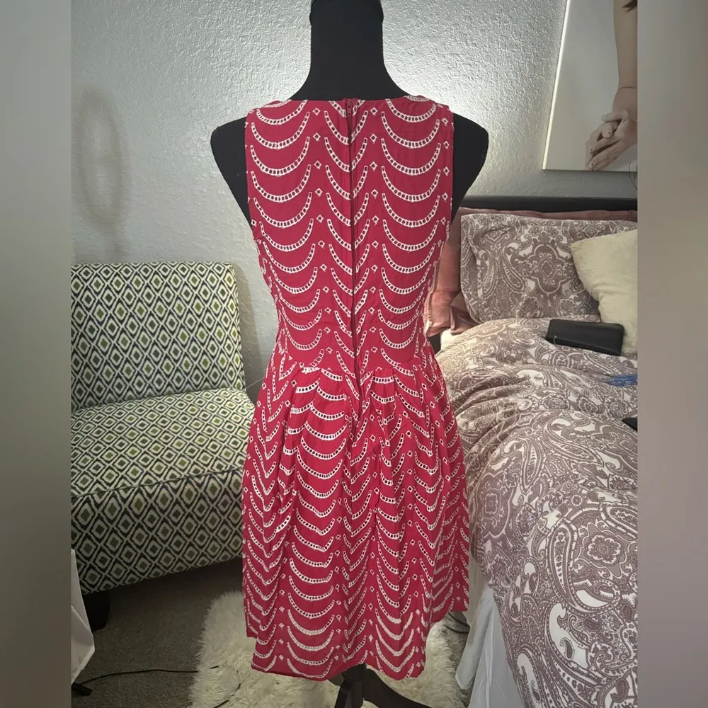 Short red dress with a white wavy line print design. It features a V - Image 4