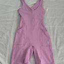 Free People Movement Here On Out Strappy Onesie Romper   Size XS  Condition: NWT  Color: bright orchid   Details : - See photo for approx. inseam measurement laying flat  - Built-in bra - not padded - Side pockets. Photo 0