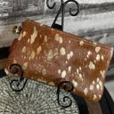 Brown cowhide with gold acid wash. 10”x6” wristlet with removable strap. Photo 0