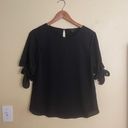 Ann Taylor black tie-sleeve blouse -SP  Gently used and in very good condition other than one tiny snag on left sleeve as circled. Size petite small.  black polyester blouse with bow tie sleeves. $80 retail. Photo 2