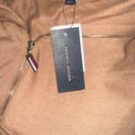 Tommy Hilfiger NWT Zip-up Hoodie Classic Sweatshirt With Drawstrings Size S // M New with tag Same day shipping Smoke and pets free Elevate your casual look with this trendy zip-up hoodie. This versatile piece features a high neckline, long sleeves, and a solid pattern that will complement any outfit. Its full zip closure, easy care fabric, and pockets make it perfect for travel, gym & training, track & field, walking, beach, golf, cross training, CrossFit, skateboarding, hiking, cheerleading, running & jogging. Made of a mix of polyester and cotton blends, this hoodie is machine washable and comes in sizes S and M. Its classic and preppy style with outdoor and all-seasons themes will surely make it a staple piece in your wardrobe. Whether you wear it for activewear or casual occasions, this hoodie is a must-have. Photo 4