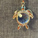 Adorable, gold tone necklace with a turtle the eyes are glass.​ Photo 3