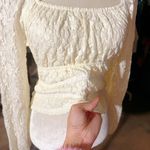 Love, Fire Love Fire Los Angeles cream Ivory peplum peasant top floral lace full lined off shoulder stretchy tie waist New with tag Same day shipping Smoke and pets free Introducing the beautiful Love Fire Los Angeles cream peplum peasant top with a gorgeous floral lace design, fully lined for maximum comfort and stretchy for a perfect fit. This top is perfect for any occasion, whether it's a night out with friends or a day time event. The long sleeves and ivory color give it a sophisticated look, while the angel character and peasant theme add a unique touch. With a regular size type and size S, this blouse will fit most women comfortably. Its features include a fabric type of lace, making it the perfect addition to any wardrobe. This top is ideal for those who want to look trendy and fashionable without sacrificing comfort. Photo 5