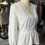 Rose & Grey LOS ANGELES white lace V-neck long sleeve shirt top peplum tie cuff  New with tag  Smoke and pets free  Same day shipping Elevate your wardrobe with this stunning white lace blouse from . The V-neckline and long sleeves add a touch of elegance to this top, while the peplum and tie cuff details create a flattering silhouette. The angel character and rose theme make it perfect for any occasion, from casual outings to formal events.   Crafted from high-quality lace fabric, this blouse features adjustable features and is available in size S. The solid pattern and delicate lace accents make it a versatile piece that can be paired with any bottom. Whether you're dressing up or down, this  blouse is sure to turn heads. Photo 4