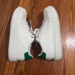 White sneakers with some green on the back of the shoe size 7.5. Photo 0