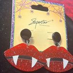 Halloween pierced adorable lips with two fangs. The red on the lips are sparkly. Photo 0