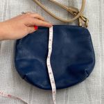 Charming Charlie small blue crossbody bag with tan strap. Photo 7