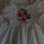 Charming white dress with pink floral embroidery. Features ruffled sleeves and hem. Perfect for casual outings. Size none Photo 4
