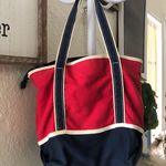 Avon red and navy nautical canvas tote bag with a zipper closure and interior pockets and an outer pocket Photo 1