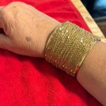 Intricate Gold Cuff Bracelet with Textured Surface and Decorative Element Photo 0