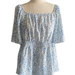 Bloomchic NWT- Adorable white with blue flowers babydoll top, smocked waist, flutter sleeves, brand new, size 14/16 Measurements: Bust: armpit to armpit 21 inches  Waist: side to side 18-24 inches  Length: shoulder seam to bottom 29 inches Photo 0