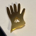 Vintage hand pin. It is gold tone with a heart in the middle of the hand.​​ Photo 2