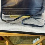 Crossbody dark blue with a Z emblem on the front but no markings on the bag.​​​ Photo 4