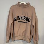 Sunkissed Coconut tan quarter zip sweater with brand in black writing Photo 5