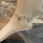 Elegant gold anklet with blue evil eye charms. Photo 3