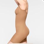 SKIMS SEAMLESS SCULPT MID THIGH BODYSUIT, in the color tan ochre. Photo 2