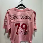 Her Universe Strawberry Shortcake and Custard Cat Women's Cropped Pink Football Jersey Photo 10