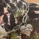 Boutique Criss Cross Ponytail Hat featuring a camo print and a Mom Heart Trucker Band. Photo 3