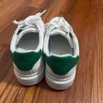 White sneakers with some green on the back of the shoe size 7.5. Photo 2
