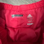 Adidas Women's Vibrant Red Athletic Shorts with Green Trim are a size Large. Photo 10