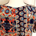 Angashion | Navy/burnt orange print short sleeve scoop neck top with tie accent. Photo 5