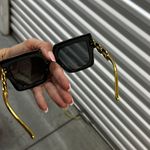 Stylish black sunglasses featuring a gold chain design. Photo 3