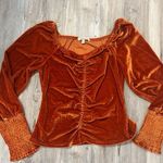 Orange velvet blouse with puffed sleeves and ruched detail # Photo 0