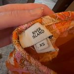 River Island 70s print ring trim beach romper in orange Photo 4