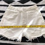 Mid/High waisted white denim shorts with frayed hem and raw hem, zipper and button closure. Size XS Photo 3