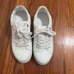 White sneakers with some green on the back of the shoe size 7.5. Photo 1