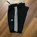Adidas  unisex Black Joggers with White Stripes are a size medium. Photo 3