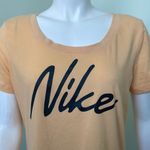 Nike  Women’s Dri-FIT Script-Logo Orange Scoop Neck Training T-Shirt Medium Photo 1