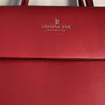 London Fog red faux leather. Adjustable strap and handles. GUC Photo 1