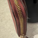 Coach Accordion Zip Wallet in a Plum color with gold tone hardware. Photo 4