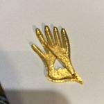 Vintage hand pin. It is gold tone with a heart in the middle of the hand.​​ Photo 1