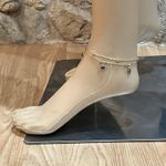 Elegant gold anklet with blue evil eye charms. Photo 1