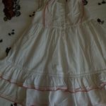Charming white dress with pink floral embroidery. Features ruffled sleeves and hem. Perfect for casual outings. Size none Photo 9