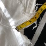 Mid/High waisted white denim shorts with frayed hem and raw hem, zipper and button closure. Size XS Photo 5