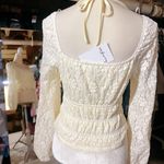 Love, Fire Love Fire Los Angeles cream Ivory peplum peasant top floral lace full lined off shoulder stretchy tie waist New with tag Same day shipping Smoke and pets free Introducing the beautiful Love Fire Los Angeles cream peplum peasant top with a gorgeous floral lace design, fully lined for maximum comfort and stretchy for a perfect fit. This top is perfect for any occasion, whether it's a night out with friends or a day time event. The long sleeves and ivory color give it a sophisticated look, while the angel character and peasant theme add a unique touch. With a regular size type and size S, this blouse will fit most women comfortably. Its features include a fabric type of lace, making it the perfect addition to any wardrobe. This top is ideal for those who want to look trendy and fashionable without sacrificing comfort. Photo 2