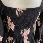 Allie Rose NWT- Beautiful black top with pink flowers, smocked back, 3/4 sleeves, ruffle bottom, brand new, size medium  Measurements: Bust: armpit to armpit 17-20 inches  Waist: side to side 14-16 inches  Length: shoulder seam to bottom 33 inches Photo 7