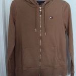Tommy Hilfiger NWT Zip-up Hoodie Classic Sweatshirt With Drawstrings Size S // M New with tag Same day shipping Smoke and pets free Elevate your casual look with this trendy zip-up hoodie. This versatile piece features a high neckline, long sleeves, and a solid pattern that will complement any outfit. Its full zip closure, easy care fabric, and pockets make it perfect for travel, gym & training, track & field, walking, beach, golf, cross training, CrossFit, skateboarding, hiking, cheerleading, running & jogging. Made of a mix of polyester and cotton blends, this hoodie is machine washable and comes in sizes S and M. Its classic and preppy style with outdoor and all-seasons themes will surely make it a staple piece in your wardrobe. Whether you wear it for activewear or casual occasions, this hoodie is a must-have. Photo 2