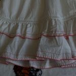 Charming white dress with pink floral embroidery. Features ruffled sleeves and hem. Perfect for casual outings. Size none Photo 5