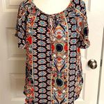 Angashion | Navy/burnt orange print short sleeve scoop neck top with tie accent. Photo 0