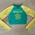 Edikted  - Brooklyn Babe Long Sleeve Crop Graphic Tee in Green and Yellow Photo 0