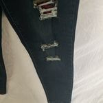 Tractr: Stretchy Skinny Jeans with red flannel covered holes Photo 6