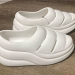 UGG W Sport Yeah EVA Platform Waterproof Clogs Shoes WHITE Foam Rubber slipper  New with tag  Same day shipping  Smoke and pets free  Step out in style with the  W Sport Yeah EVA Platform Waterproof Clogs Shoes. These slip-on clogs feature a round toe shape and a flat heel style. The shoe is designed with a solid pattern and a white color, making it perfect for beach outings and fashion-conscious women.  Made with EVA fabric type, the clogs offer ultimate comfort and are waterproof and slip-resistant.  has designed them as activewear, travel, and casual wear clogs, suitable for any occasion. The shoe is available in a standard shoe width and is perfect for women who wear a US shoe size of 5 or a UK shoe size of 3. Photo 1