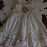 Charming white dress with pink floral embroidery. Features ruffled sleeves and hem. Perfect for casual outings. Size none Photo 3