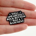 Well Apparently Rock Bottom Has A Basement Enamel Pin Black Photo 0